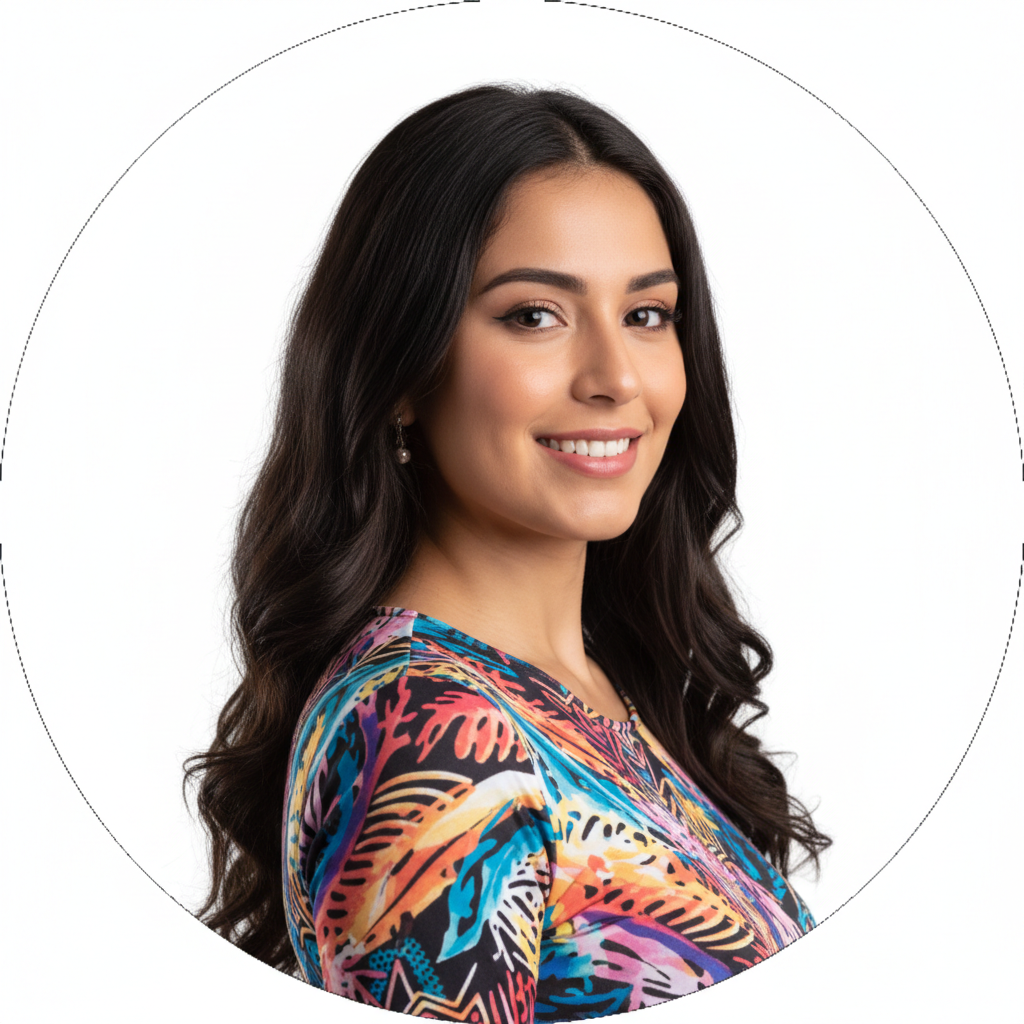 A smiling woman with long dark wavy hair and a colorful patterned shirt poses against a white background.